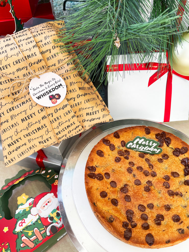 Giant chocolate chip cookie on holiday table with festive decorations